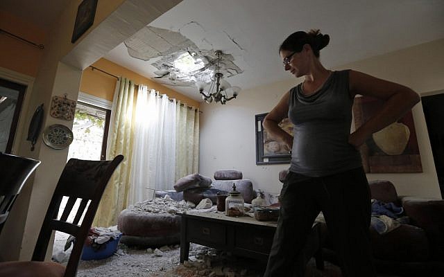 A woman surveys the damage to her house after a rocket fired by Palestinian terrorists from the Gaza Strip hit a community in southern Israel, Wednesday, Oct. 24, 2012 (photo credit: AP/ Tsafrir Abayov) A woman surveys the damage to her house after a rocket fired by Palestinian terrorists from the Gaza Strip hit a community in southern Israel, Wednesday, Oct. 24, 2012 (photo credit: AP/ Tsafrir Abayov)
