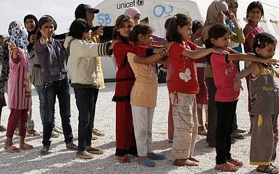 Syrian refugee children stand in line before attending class at the Zaatari refugee camp in Mafraq, Jordan, on Thursday, October 4, 2012 (photo credit: AP Photo/Raad Adayleh)