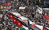 Thousands of Islamic Action Front supporters carrying banners and a large Jordanian flag gather earlier this month to demand constitutional reforms during an opposition rally in Amman. (photo credit: AP/Raad Adayleh)