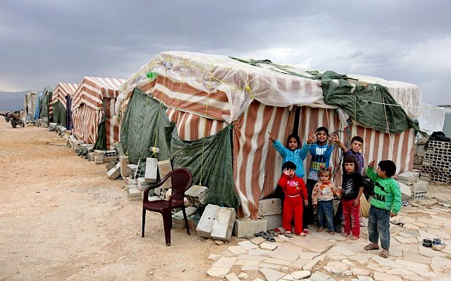 Syrian refugee children flash victory signs as they stand in front of their tents at a refugee camp in Arsal (photo credit: AP Photo/Bilal Hussein)