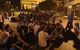 Anti-government protesters in Lebanon sit on the ground Friday in front the government palace, seen in the background, during a demonstration after a bomb killed Brig. Gen. Wissam al-Hassan and seven others in Beirut. (photo credit: AP Photo/Hussein Malla)