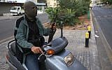 A Sunni gunman holds his AK-47 as he rides a scooter on a blocked street leading to a Shiite neighborhood after overnight clashes between Sunni and Shiite gunmen in Beirut, Lebanon, Monday October 22, 2012 (photo credit: AP/Hussein Malla)