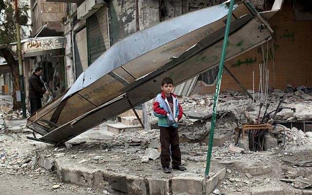 A boy stands in front of a shop destroyed from Syrian Army shelling in the center of Idlib, in northern Syria on Monday, Feb. 27, 2012. (photo credit: Rodrigo Abd/AP) A boy stands in front of a shop destroyed from Syrian Army shelling in the center of Idlib, in northern Syria on Monday, Feb. 27, 2012. (photo credit: Rodrigo Abd/AP)