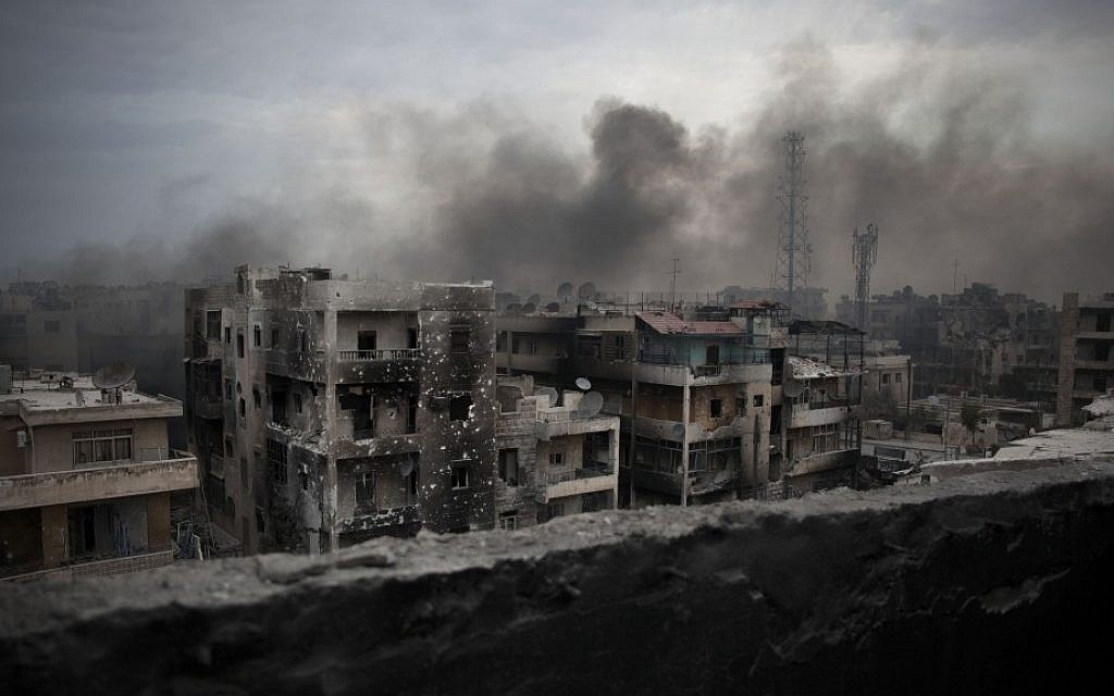 Smoke rises over Saif Al Dawla district in Aleppo, Syria earlier this month (photo credit: AP/ Manu Brabo)