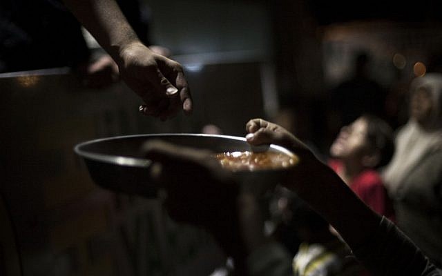 A Syrian boy, who fled his home with his family due to fighting between government forces and rebels, holds a plate with food to eat at a refugee camp near the Turkish border, Azaz, Syria, Sunday. (AP Photo/ Manu Brabo)