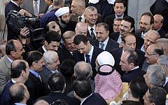 Syrian President Bashar Assad, center, shakes hands with worshipers at a mosque last October. (photo credit: AP)