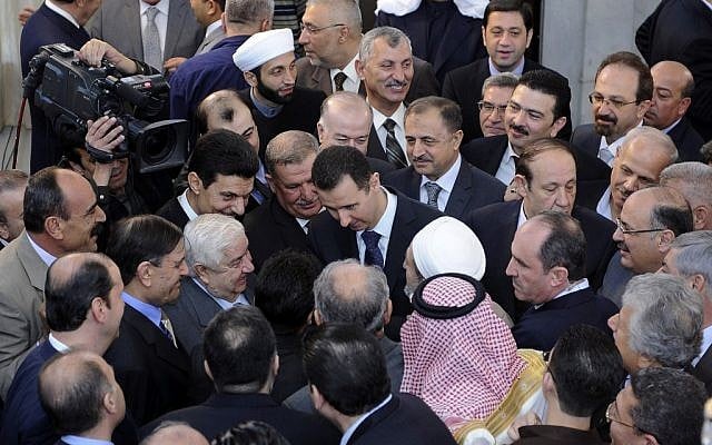 Syrian President Bashar Assad, center, shakes hands with worshipers at a mosque last October. (photo credit: AP) Syrian President Bashar Assad, center, shakes hands with worshipers at a mosque last October. (photo credit: AP)