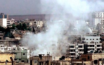 This image taken from video obtained from the Shaam News Network, which has been authenticated based on its contents and other AP reporting, purports to show smoke rising from buildings due to government forces shelling in Daraa, Syria, on Tuesday, Oct. 2, 2012. (photo credit: AP Photo/Shaam News Network via AP video)