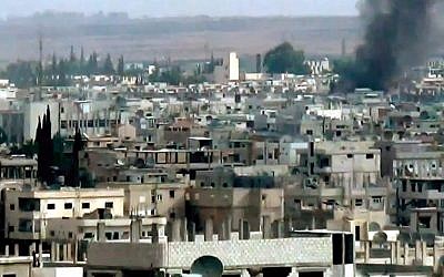 This image taken from video obtained from the Shaam News Network, which has been authenticated based on its contents and other AP reporting, purports to show smoke rising from buildings due to government forces shelling in Daraa, Syria, on Tuesday, Oct. 2, 2012. (photo credit: AP Photo/Shaam News Network via AP video)