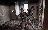 Free Syrian Army soldier throws a petrol bomb at Syrian Army positions in Saif Al Dawle district in Aleppo, October 3 (photo credit: AP/ Manu Brabo)