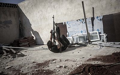 A rebel fighter fires a gun at an army jet flying a bombing run on nearby rebel positions in the district of Aleppo Jedida, Syria, on Monday, October 29, 2012 (photo credit: AP Photo/Narciso Contreras)