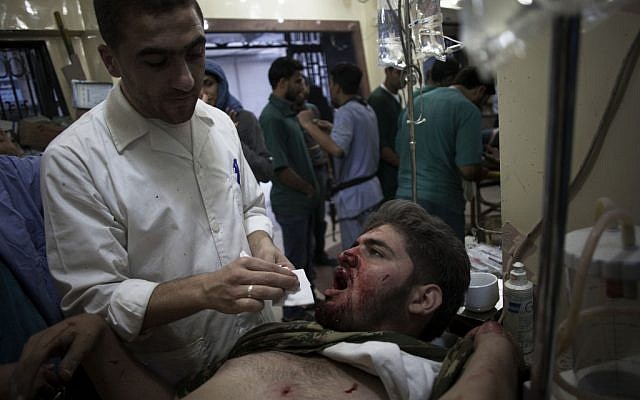 A Syrian doctor treats a wounded Free Syrian Army fighter at Dar al-Shifa hospital in Aleppo, October 13 (AP Photo/ Manu Brabo)