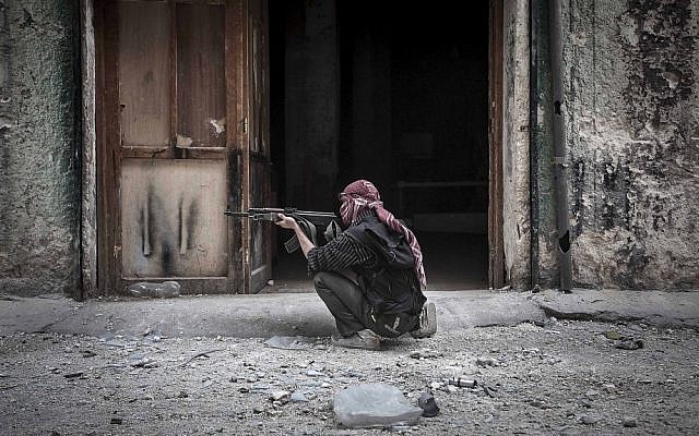 A Free Syrian Army fighter takes aim at a government position in Aleppo, Syria on Wednesday (photo credit: AP/Narciso Contreras)