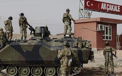Turkish soldiers patrol a military station at the border crossing with Syria in Akçakale, across from the Syrian rebel-controlled town of Tel Abyad in October. Syria and Turkey exchange fire across their troubled border for a sixth straight day, attacks that look increasingly like an intentional escalation by President Bashar Assad to send a message to his northern neighbor that it will pay dearly for supporting the rebels. (photo credit: AP)