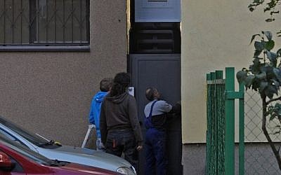 Workers adjust a gate in front of one of the world’s narrowest houses, in Warsaw, Poland, Friday, Oct. 19 (photo credit: AP/Alik Keplicz)