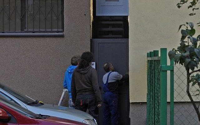 Workers adjust a gate in front of one of the world’s narrowest houses, in Warsaw, Poland, Friday, Oct. 19 (photo credit: AP/Alik Keplicz) Workers adjust a gate in front of one of the world’s narrowest houses, in Warsaw, Poland, Friday, Oct. 19 (photo credit: AP/Alik Keplicz)