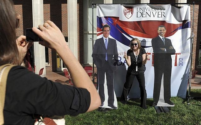 Ellen Leslie, left, takes a photo of Danielle Gillespie, right, with cardboard cut-outs of Mitt Romney and President Barack Obama at DebateFest at the University of Denver on Wednesday, Oct. 3, 2012, in Denver. (Chris Schneider/AP)