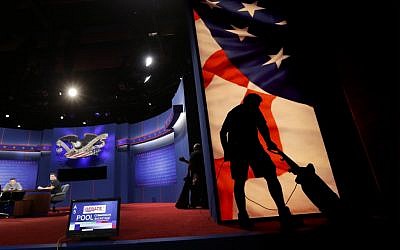 A worker vacuums the set for Monday's presidential debate in Boca Raton, Florida. (photo credit: AP Photo/Eric Gay)