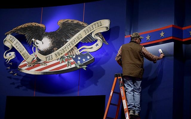 A worker cleans lint off the background of the stage for a debate at the University of Denver ,Tuesday, Oct. 2, 2012, in Denver. President Barack Obama and Republican presidential candidate and former Massachusetts Gov. Mitt Romney will hold their first debate Wednesday. (photo credit: David Goldman/AP) A worker cleans lint off the background of the stage for a debate at the University of Denver ,Tuesday, Oct. 2, 2012, in Denver. President Barack Obama and Republican presidential candidate and former Massachusetts Gov. Mitt Romney will hold their first debate Wednesday. (photo credit: David Goldman/AP)