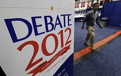 A worker walks past a sign in the media filing center before Tuesday's presidential debate between President Barack Obama and Republican presidential candidate, former Massachusetts Gov. Mitt Romney, Monday, Oct. 15, 2012, at Hofstra University in Hempstead, NY. (photo credit: Charlie Neibergall/AP)