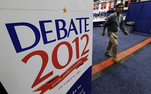 A worker walks past a sign in the media filing center before Tuesday's presidential debate between President Barack Obama and Republican presidential candidate, former Massachusetts Gov. Mitt Romney, Monday, Oct. 15, 2012, at Hofstra University in Hempstead, NY. (photo credit: Charlie Neibergall/AP) A worker walks past a sign in the media filing center before Tuesday's presidential debate between President Barack Obama and Republican presidential candidate, former Massachusetts Gov. Mitt Romney, Monday, Oct. 15, 2012, at Hofstra University in Hempstead, NY. (photo credit: Charlie Neibergall/AP)
