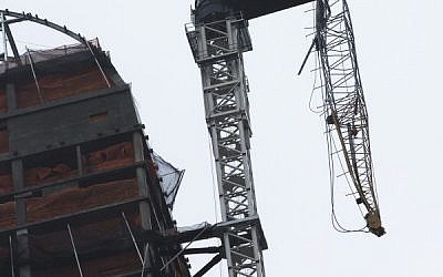 A construction crane atop a luxury high-rise dangles precariously over the streets after collapsing in high winds from Hurricane Sandy, Monday, Oct. 29, 2012, in New York. (photo credit: John Minchillo/AP)
