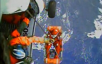 In this video image capture released by the US Coast Guard, a USCG crew member uses a hoist to bring up a survivor from the HMS Bounty into a helicopter. (photo credit: AP/U.S. Coast Guard)