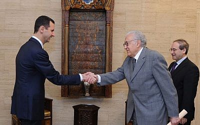 Syrian President Bashar Assad, left, greets UN and Arab League envoy Lakhdar Brahimi prior to their closed-door meeting in Damascus, Syria, Sunday Oct. 21 (photo credit: AP/SANA)