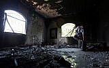 A Libyan man investigates the inside of the US Consulate in Benghazi, Libya, after an attack that killed four Americans, including Ambassador Chris Stevens on the night of Tuesday, Sept. 11, 2012 (photo credit: AP/Mohammad Hannon/File)