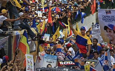 Opposition presidential candidate Henrique Capriles Radonski, center, gestures to supporters during a campaign rally in Caracas, Venezuela on Sunday (photo credit: AP/Fernando Llano)