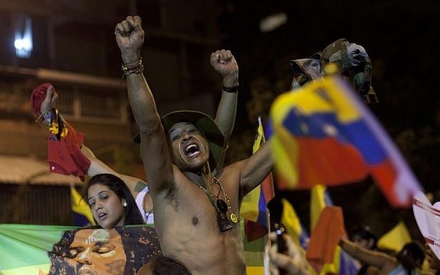 Supporters of Venezuela's President Hugo Chavez celebrate his reelection outside the Miraflores presidential palace on Sunday (photo credit: AP/Ramon Espinosa)