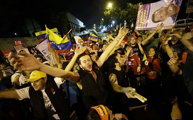 Supporters of Venezuela's President Hugo Chavez cheer after polling stations closed and before any results were made available outside Miraflores presidential place in Caracas on Sunday (photo credit: AP/Fernando Llano)