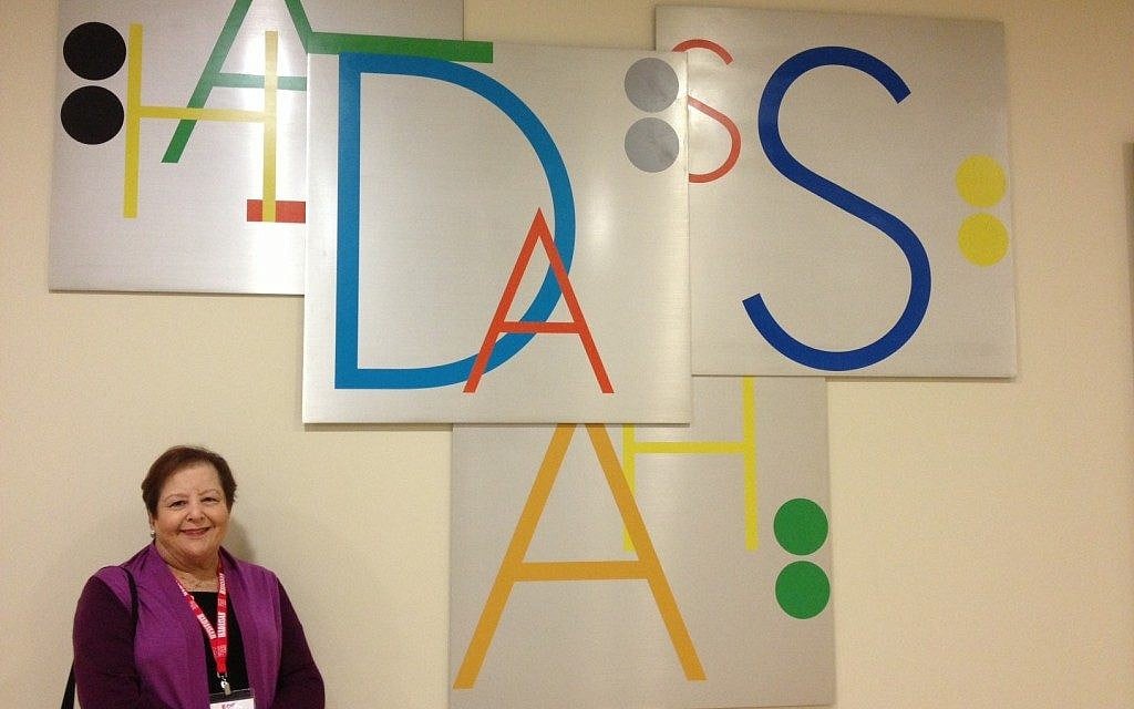Bonnie Lipton in front of one of the Yoram Vardinon-designed signs (photo credit: Jessica Steinberg/Times of Israel)