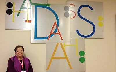 Bonnie Lipton in front of one of the Yoram Vardinon-designed signs (photo credit: Jessica Steinberg/Times of Israel)