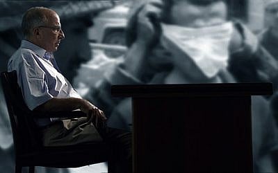 With an image of a blindfolded Palestinian prisoner in the background, retired Lt. Col. Jonathan Livny reflects on his 23 years as a military judge. (Courtesy of Cinema Guild)
