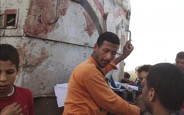 Egyptians gather at the scene of a train crash that killed at least 47 people, most of them children near Assiut in southern Egypt, Saturday, Nov. 17 (photo credit: AP/Mamdouh Thabet)