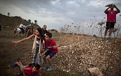 Israelis take cover as a rocket siren sounds in Tel Aviv Saturday. (photo credit: AP/Oded Balilty)