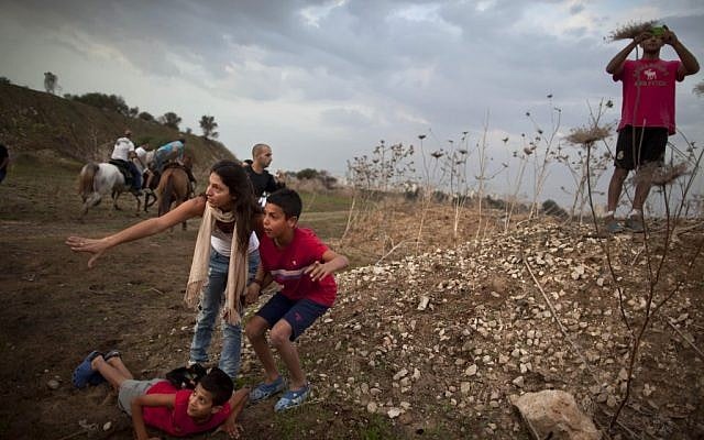 Israelis take cover as a rocket siren sounds in Tel Aviv Saturday. (photo credit: AP/Oded Balilty)