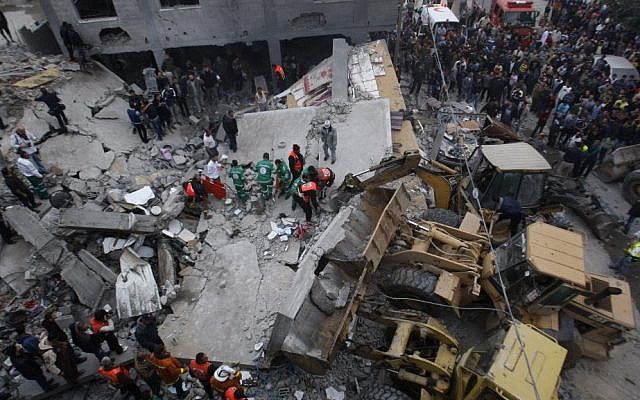 Palestinian firefighters at the scene of an Israeli air strike on a building in the Jebaliya refugee camp in the northern Gaza Strip on Saturday.(photo credit: AP Photo/Hatem Moussa)