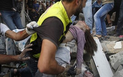 A child is carried from the Dalu house on Sunday night (photo credit: Hatem Moussa/AP)