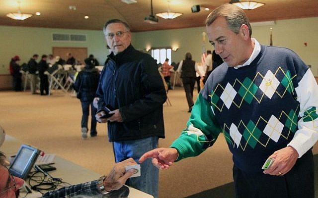 Speaker John Boehner presents his ID at a polling station in Ohio, Tuesday (photo credit: Al Behrman/AP)