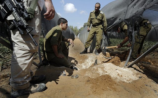 Soldiers search for a mortar shell fired by Gaza terrorists in a greenhouse in southern Israel on October 8 (photo credit: Tsafrir Abayov/Flash90)