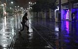 An Israeli woman runs for cover as the first rain of the year falls on Jerusalem on Friday (photo credit: Oren Nahshon/Flash90)