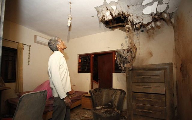 An Israeli man examines the damage caused to a house in Sderot by a Kassam rocket fired from the Gaza Strip on Sunday (photo credit: Edi Israel/Flash90) An Israeli man examines the damage caused to a house in Sderot by a Kassam rocket fired from the Gaza Strip on Sunday (photo credit: Edi Israel/Flash90)