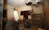 An Israeli man examines the damage to his daughter's bedroom after a Kassam rocket fired by Palestinian terrorists from Gaza hit his house in the southern town of Sderot on November 11 (photo credit: Edi Israel/Flash90)