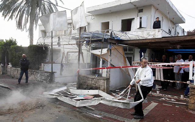 A citizen clears away wreckage caused by a Grad rocket hitting a house in Netivot on Monday, November 12 (photo credit: Edi Israel/Flash90) A citizen clears away wreckage caused by a Grad rocket hitting a house in Netivot on Monday, November 12 (photo credit: Edi Israel/Flash90)
