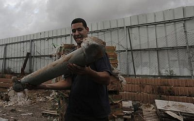 An Israeli holds the remnants of a rocket, fired by Palestinian terrorists, in the southern town of Netivot, Monday, November 12, 2012 (photo credit: Tsafrir Abayov/Flash90)
