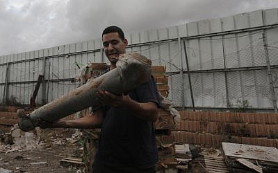 A Netivot resident holds the remains of a rocket, fired by Palestinian militants in Gaza, on Monday, Nov. 12, 2012. (photo credit: Tsafrir Abayov/Flash90)