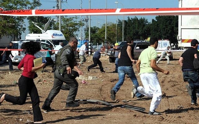 Israelis run for cover as a warning siren sounds for incoming rockets in the southern Israeli city of Kiryat Malachi, where three Israelis were killed by a rocket attack on Thursday (Photo credit: Moshe Milner/GPO/Flash90)