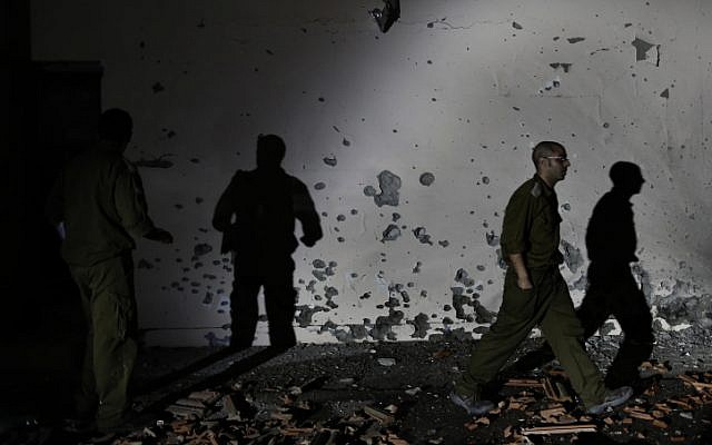 Soldiers examine a damaged wall of a house in the Be'er Tuvia region that was hit by a rocket fired from the Gaza Strip on Friday, Nov. 16 (photo credit: Tsafrir Abayov/Flash90) Soldiers examine a damaged wall of a house in the Be'er Tuvia region that was hit by a rocket fired from the Gaza Strip on Friday, Nov. 16 (photo credit: Tsafrir Abayov/Flash90)